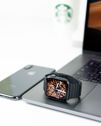 iphonex旁边笔记本电脑上的苹果手表